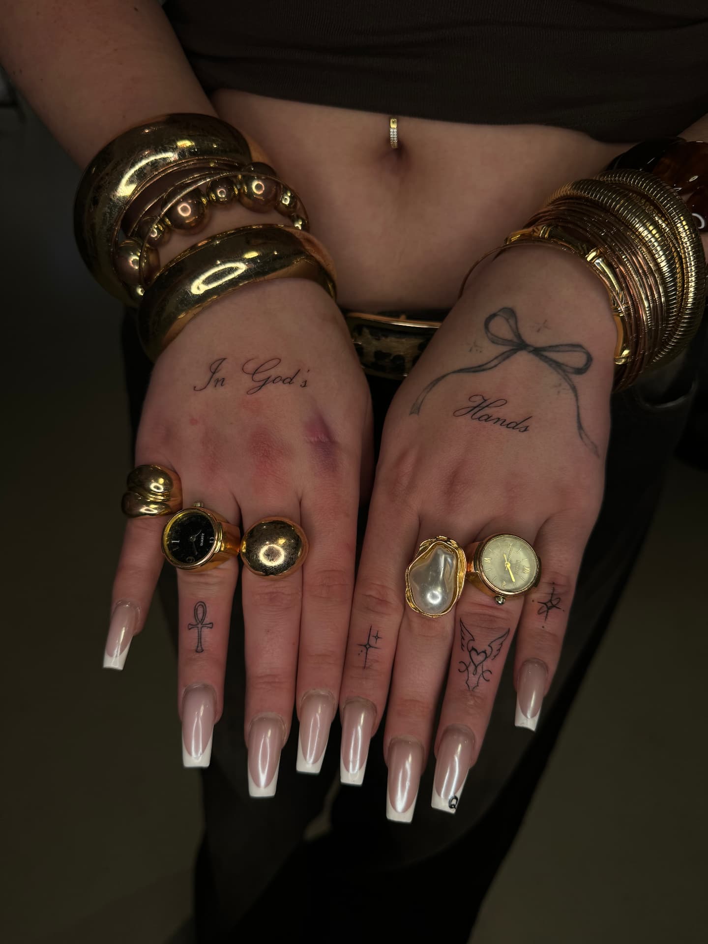 Fine line script and bow hand tattoos with gold jewellery